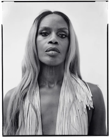 Monochrome portrait of a woman with long blonde hair and a fringed garment by photographer Andreas Laszlo Konrath.