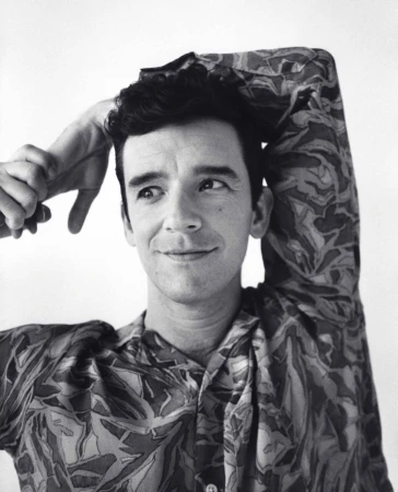 Portrait of a man in a patterned shirt with hands behind his head by photographer Andreas Laszlo Konrath.
