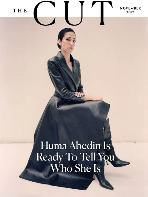 Magazine cover featuring Huma Abedin in a stylish black leather dress and boots, seated against a neutral background, text overlays the image.
