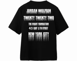 Black t-shirt featuring white distressed block lettering on the back against a seamless background
