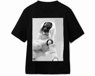 Black t-shirt featuring a central rectangular photographic print of a mannequin with a dark textured face mask and light wig.