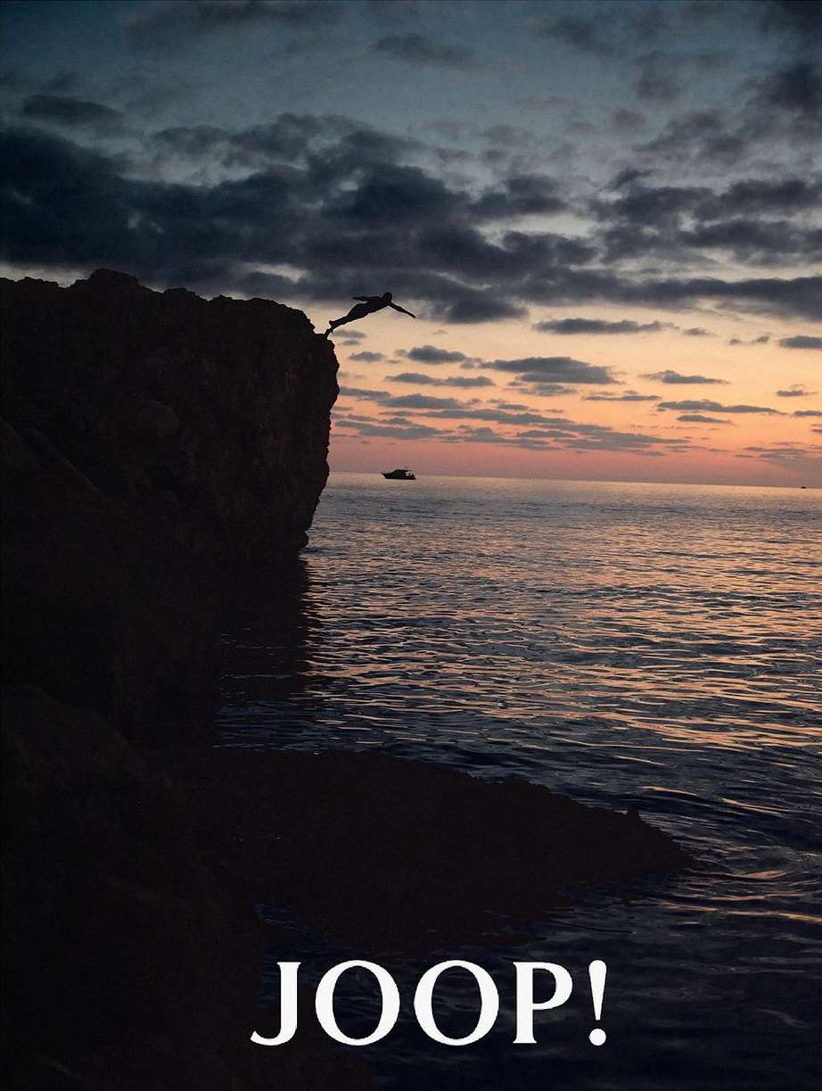 Silhouette of a person jumping off a cliff into the sea at sunset, with a small boat visible in the distance, and the text JOOP! at the bottom.