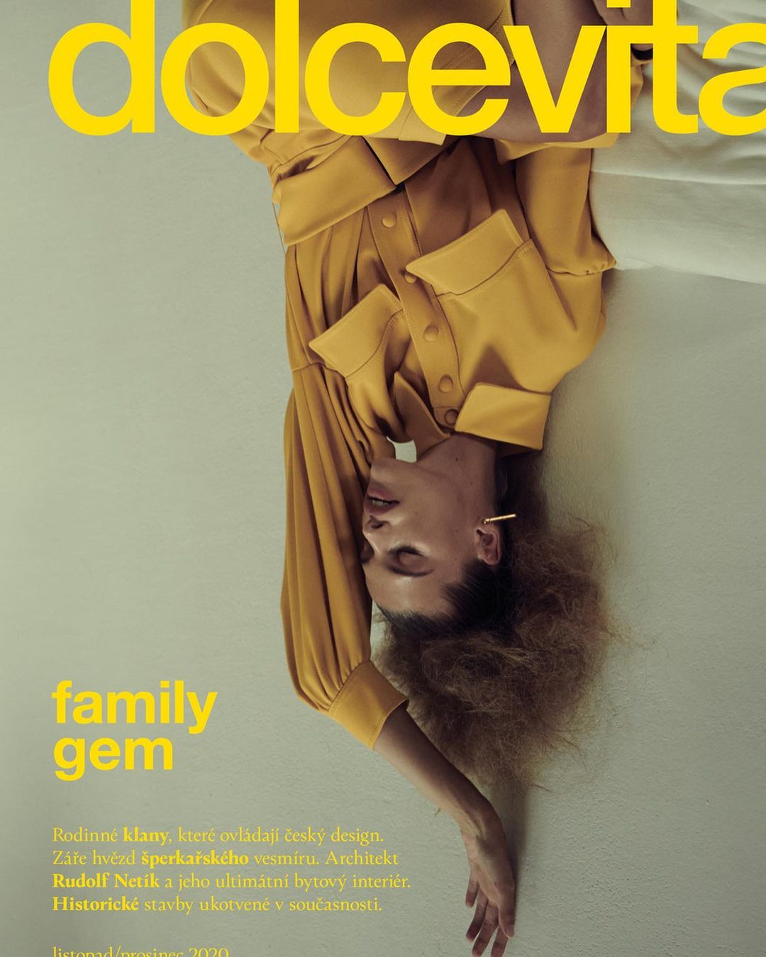 Magazine cover featuring a woman in a yellow outfit with text "dolcevita family gem". The model is upside down against a neutral background.