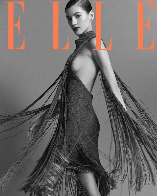Elle magazine cover featuring a woman wearing a dress with fringe, set against a grey backdrop with orange 'Elle' lettering.