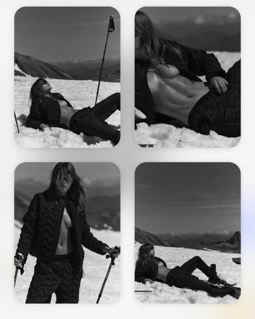Black and white fashion shot of an adult female model posing in the snow wearing outdoor quilted apparel with mountains in the background.