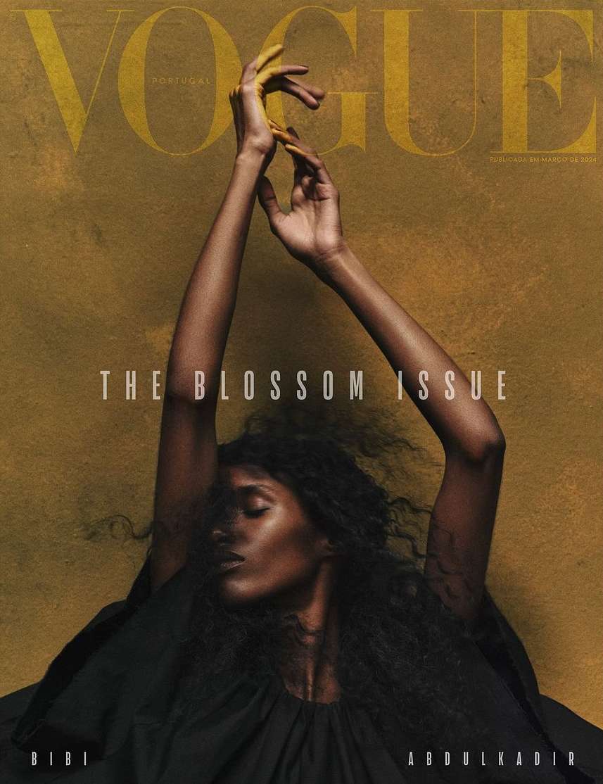 Vogue Portugal magazine cover featuring a dark-skinned woman with hands raised, styled for the Blossom Issue on a textured tan backdrop.