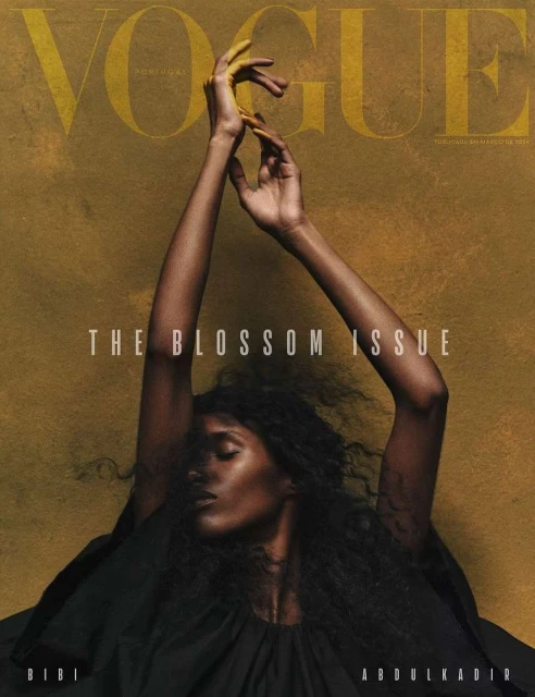Vogue Portugal magazine cover featuring a dark-skinned woman with hands raised, styled for the Blossom Issue on a textured tan backdrop.