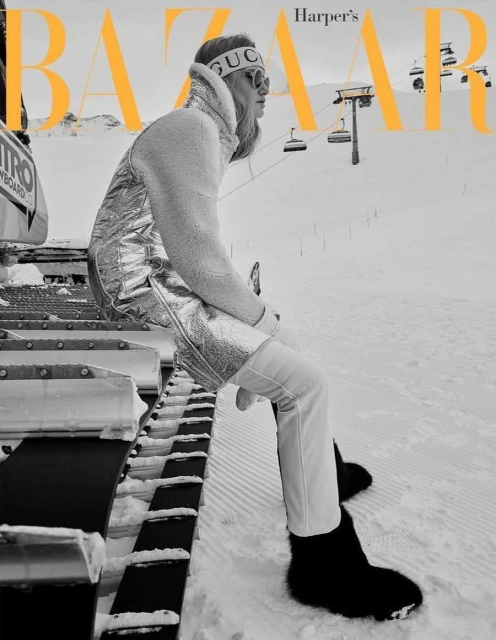 Harper's Bazaar cover featuring a blonde model in ski wear sitting on a snowplow at a ski resort, with ski lifts in the background.