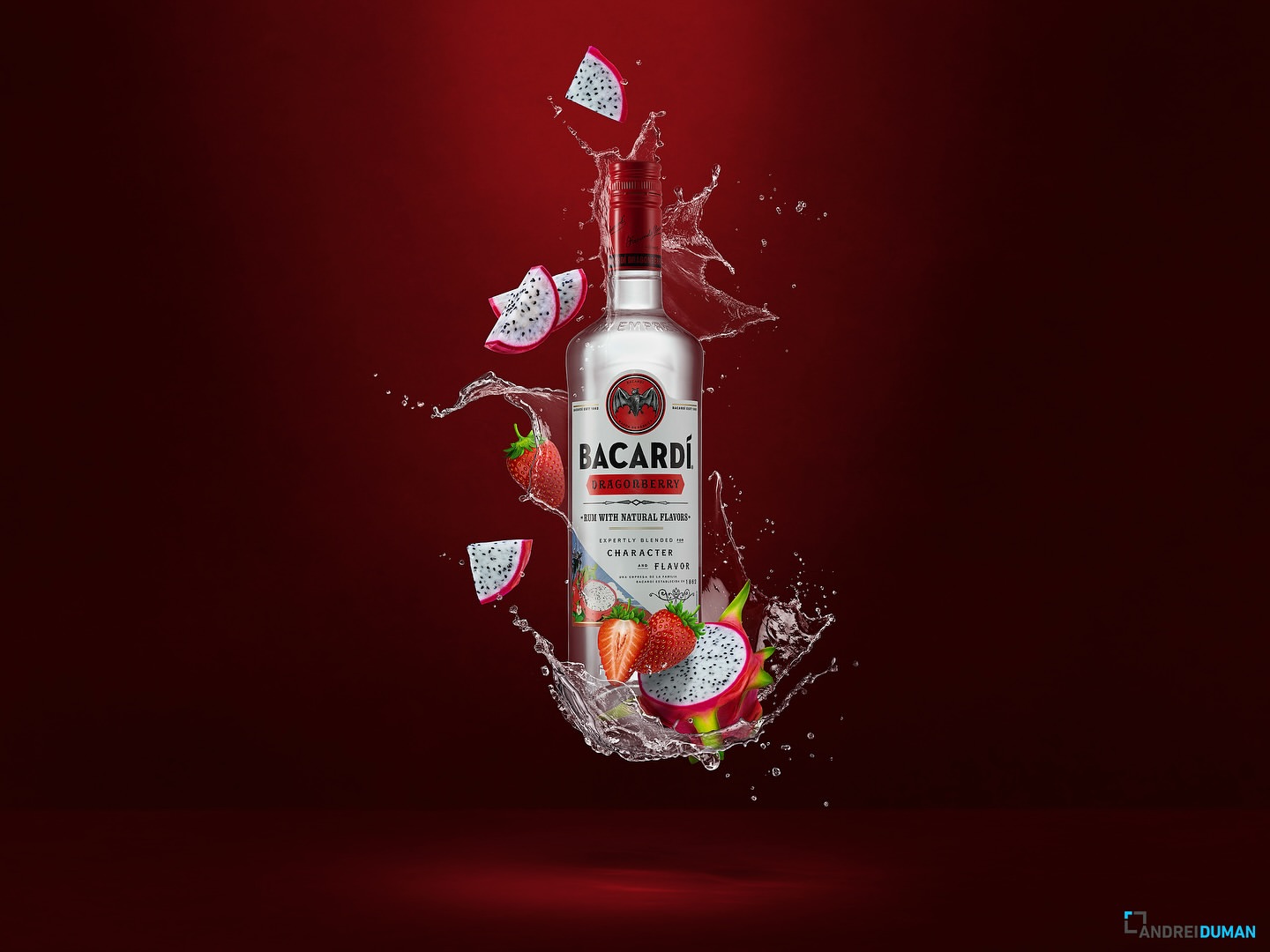 Bacardi bottle surrounded by dragon fruit and strawberries with water splashes set against a vibrant red backdrop in a studio setting.
