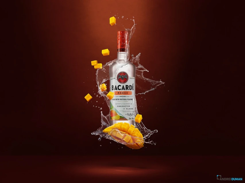 Bacardi Mango rum bottle with mango chunks and water droplets on a brown gradient background, product photography for food and beverage.