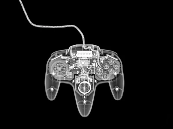X-ray image of a vintage N64 game controller with a cable, displaying its inner mechanisms against a dark backdrop.