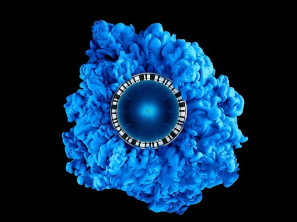 Circular technological device with blue core surrounded by abstract blue smoke effect on a stark black background.