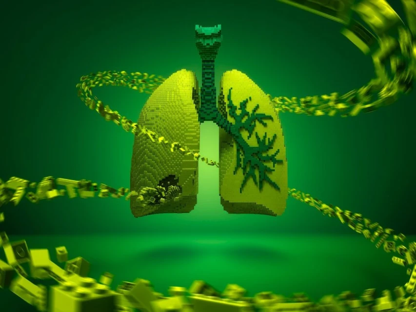 Digital 3D rendered lungs made of green pixel blocks are connected to a windpipe and surrounded by a blurry trail of green blocks.