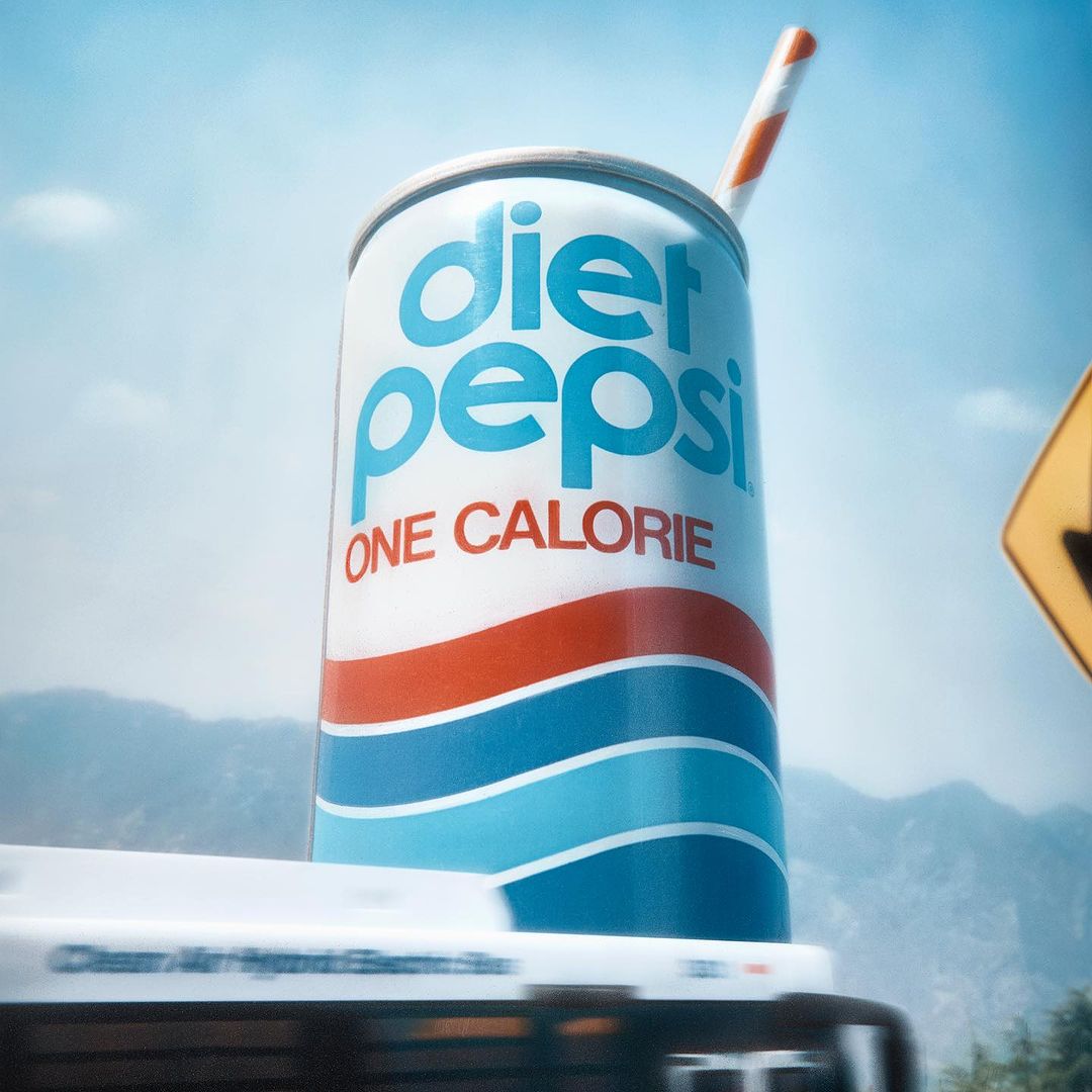 Diet Pepsi can on a moving bus, featuring a blue sky, mountains, and a straw, creating a refreshing and eye-catching soft drink ad.