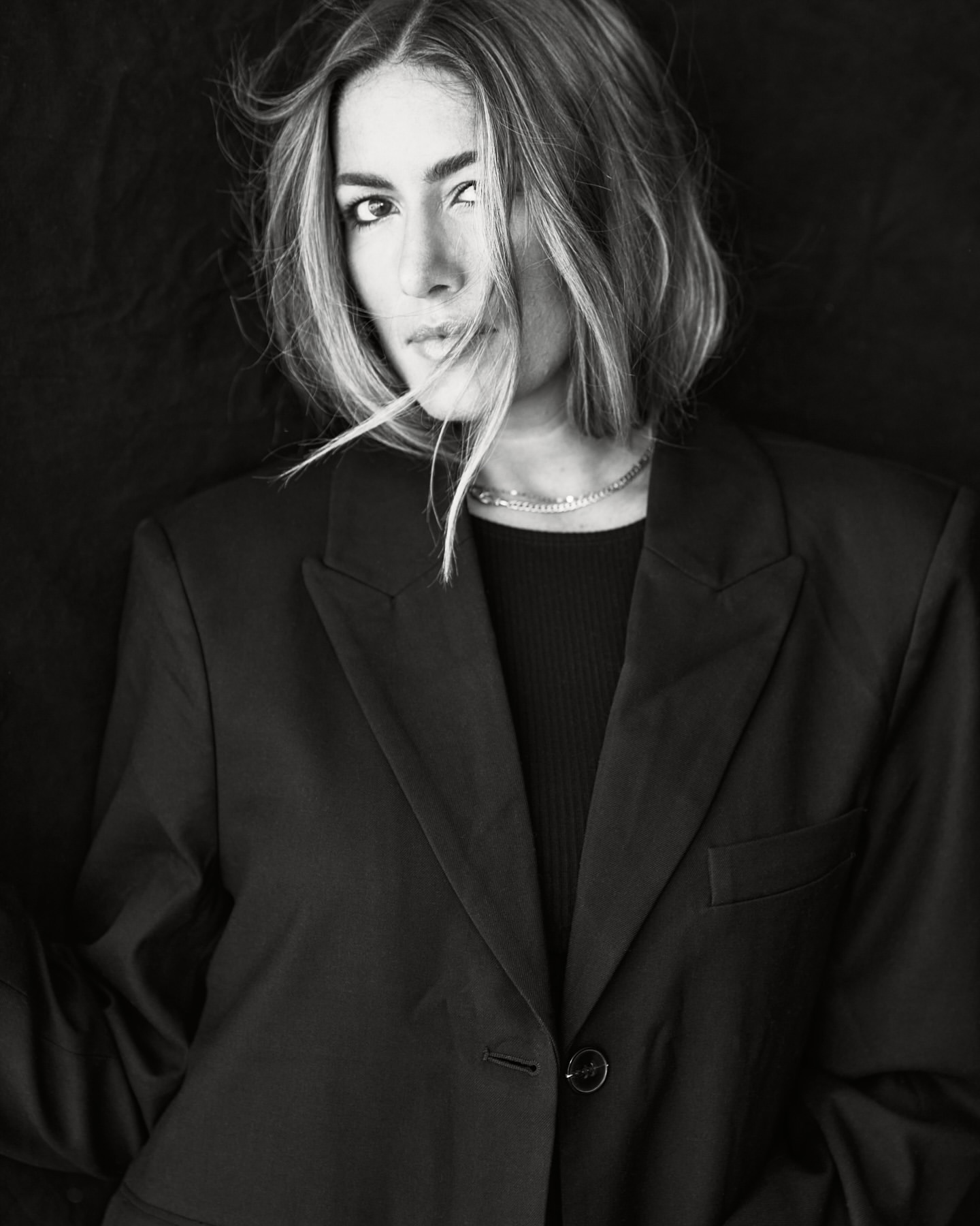Portrait of a woman with short hair wearing a dark blazer, shot in monochrome by Andrew Day.
