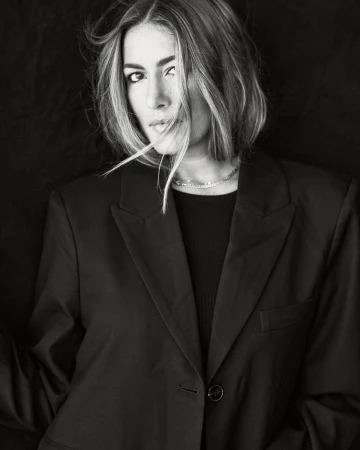 Portrait of a woman with short hair wearing a dark blazer, shot in monochrome by Andrew Day.