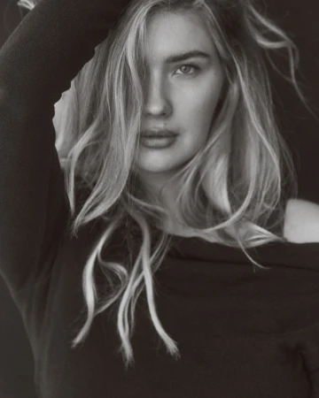 Monochrome portrait of a woman with long hair wearing a black top, photographed by Andrew Day.