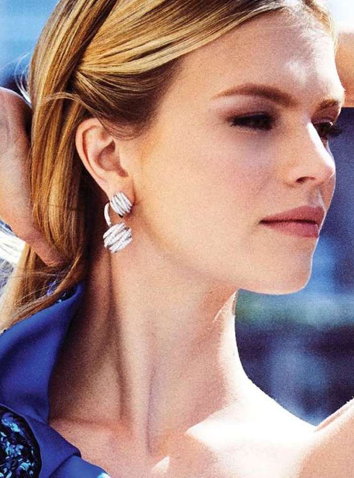 Close-up of a blonde woman with earrings. Focus on the model's face, hairstyle, and jewellery, highlighting beauty and fashion.