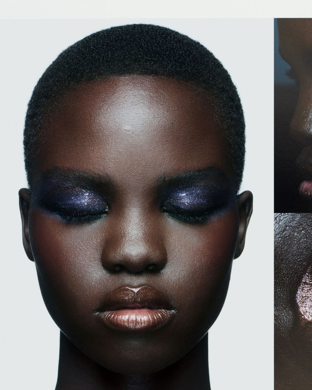 Close-up portrait of a Black female model with dramatic purple eyeshadow, glossy lips, and short dark hair against a white background.
