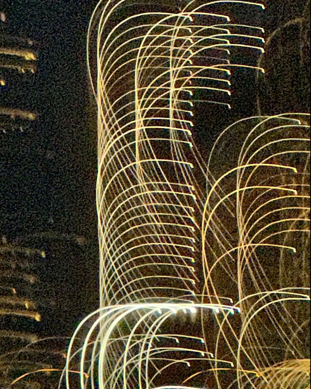 Abstract image of illuminated building at night featuring long exposure light trails creating an artistic and dynamic urban scene.