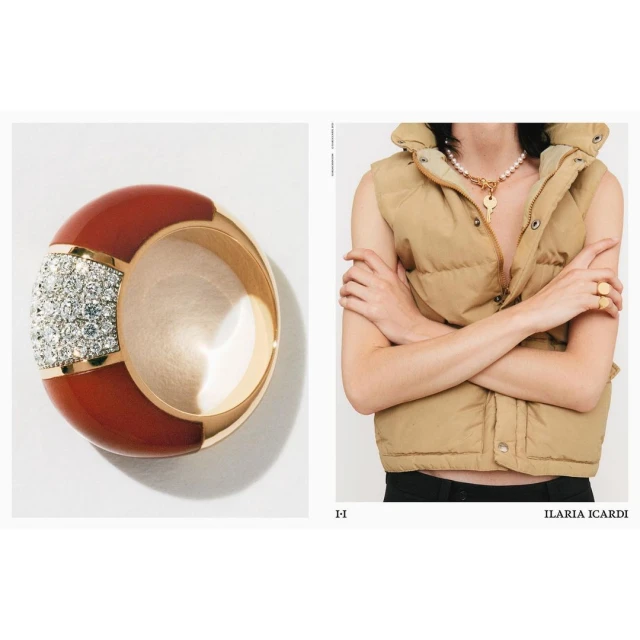 Still life shot of a red and gold ring with gemstones next to a person wearing a puffer vest and necklace with a key pendant.