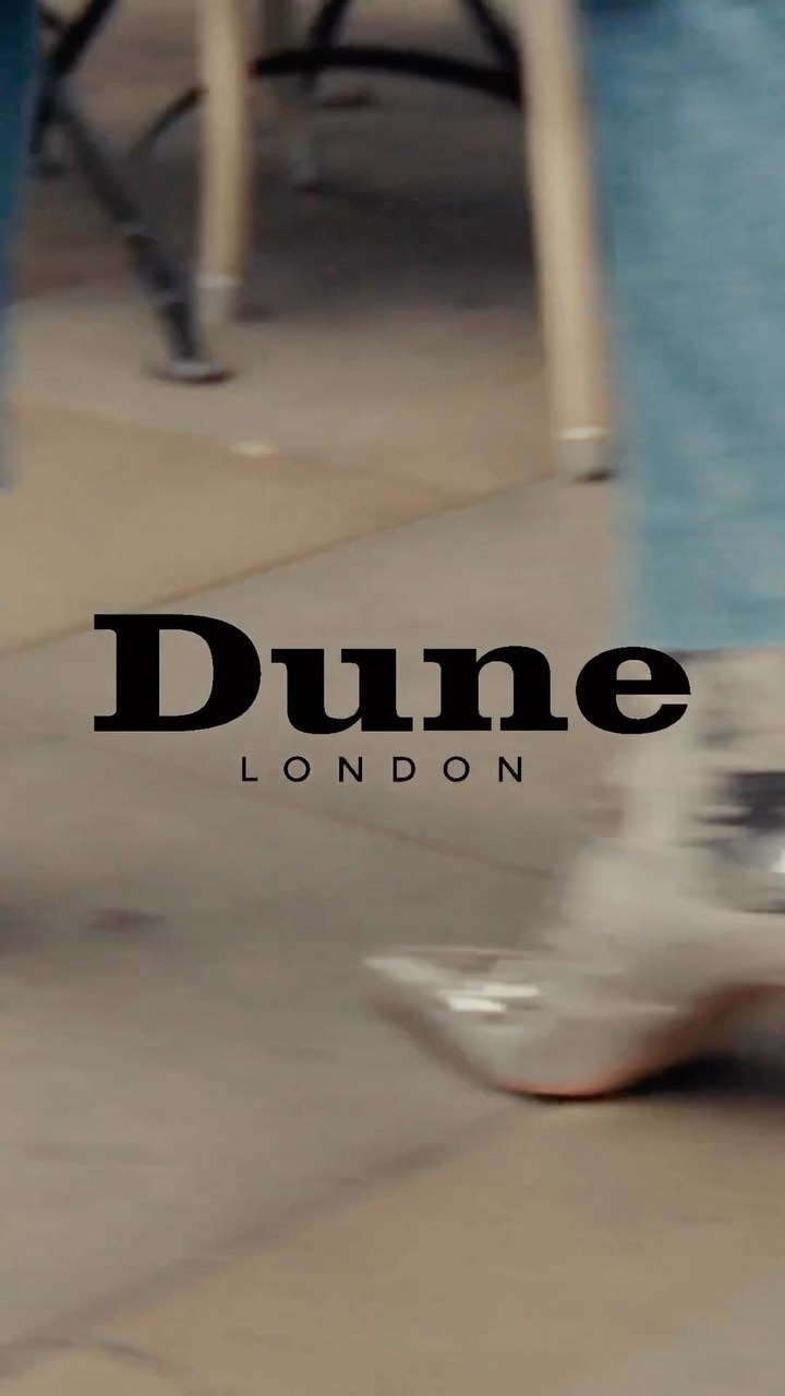 Close-up of silver shoes and light wash denim, featuring the Dune London logo over a neutral background.
