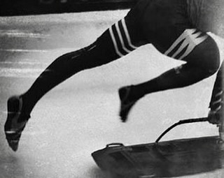 Monochrome image of a bobsledder in motion, showcasing their legs and the bobsled, emphasizing the speed and sport of bobsleighing.