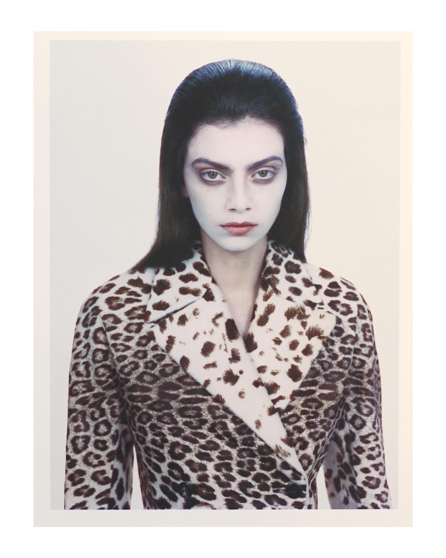 Portrait of a woman wearing a leopard print jacket against a plain light background by Andy Harrington