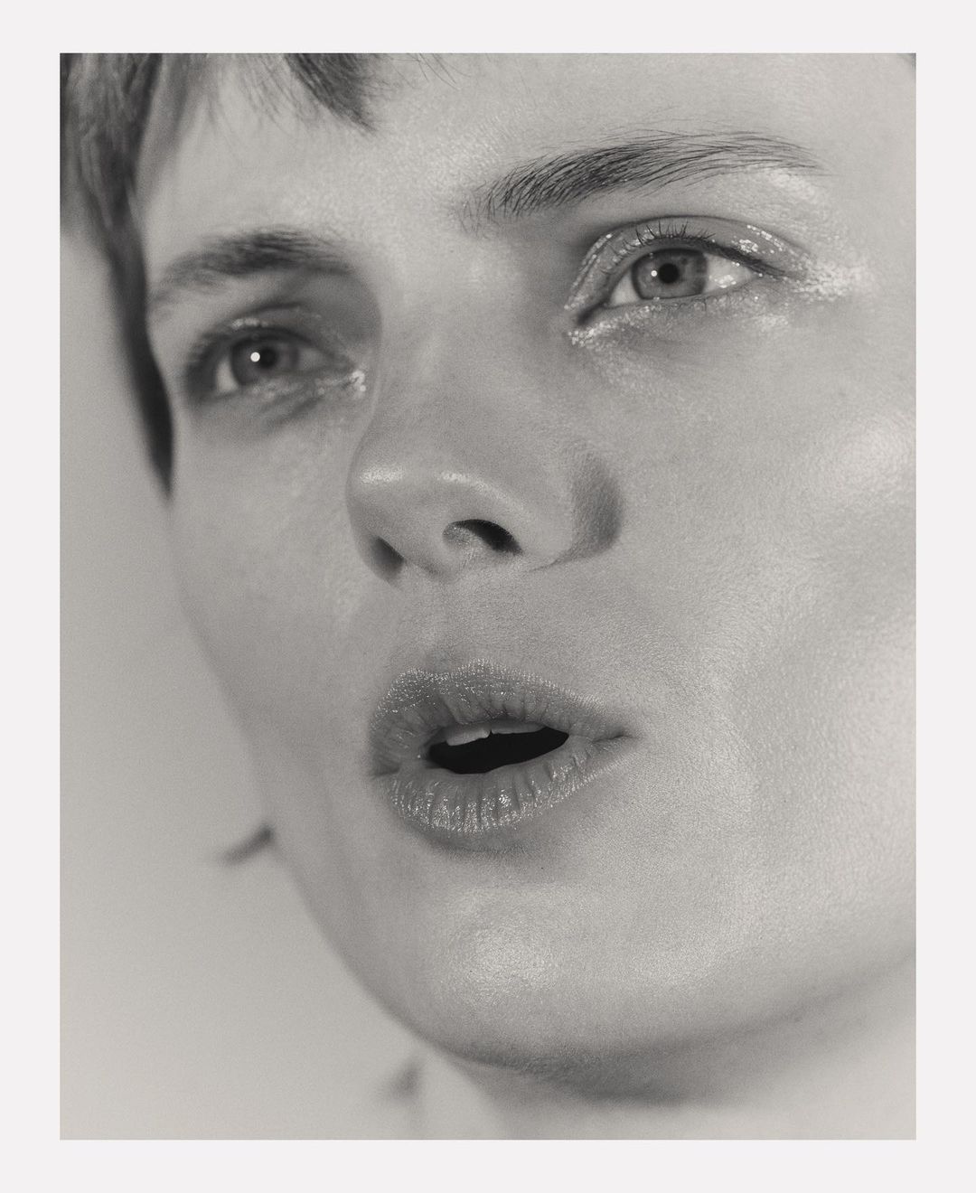 Close-up monochrome portrait of a model with short hair and glossy lips captured by photographer Andy Harrington in Paris.