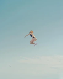 Woman in black bikini and white socks mid-air against a clear pale blue sky by photographer Andy Lo Po.