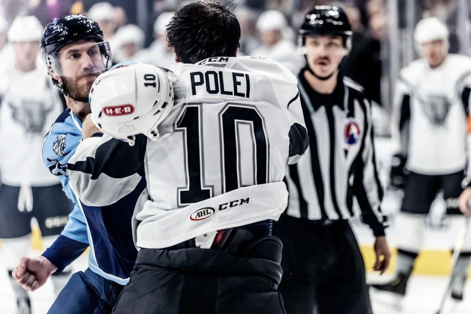 Hockey players clashing during a game on the ice rink, one player wearing a 'POLEI' jersey with the number 10 is in focus.