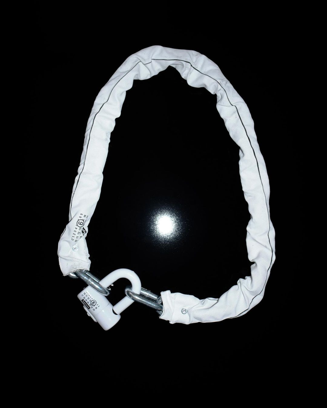 White padded chain lock and padlock with steel shackle isolated on black provides security, durability, and theft deterrent.