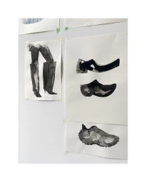 Black and white ink illustrations of shoes and legs taped to a white wall by Anje Jager in Berlin.