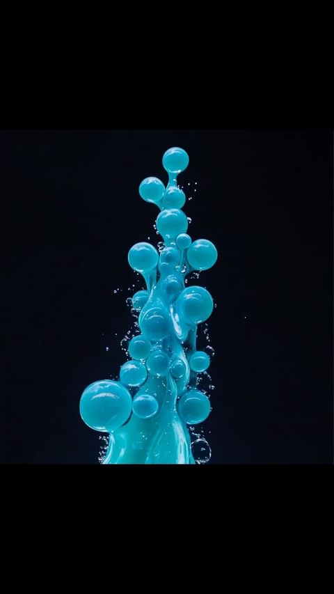 Abstract arrangement of interconnected, luminous blue spheres cascading down a dark background, resembling a unique, liquid sculpture. 