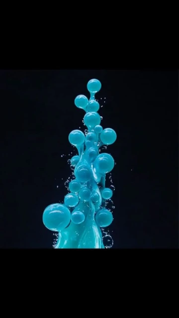 Abstract arrangement of interconnected, luminous blue spheres cascading down a dark background, resembling a unique, liquid sculpture. 