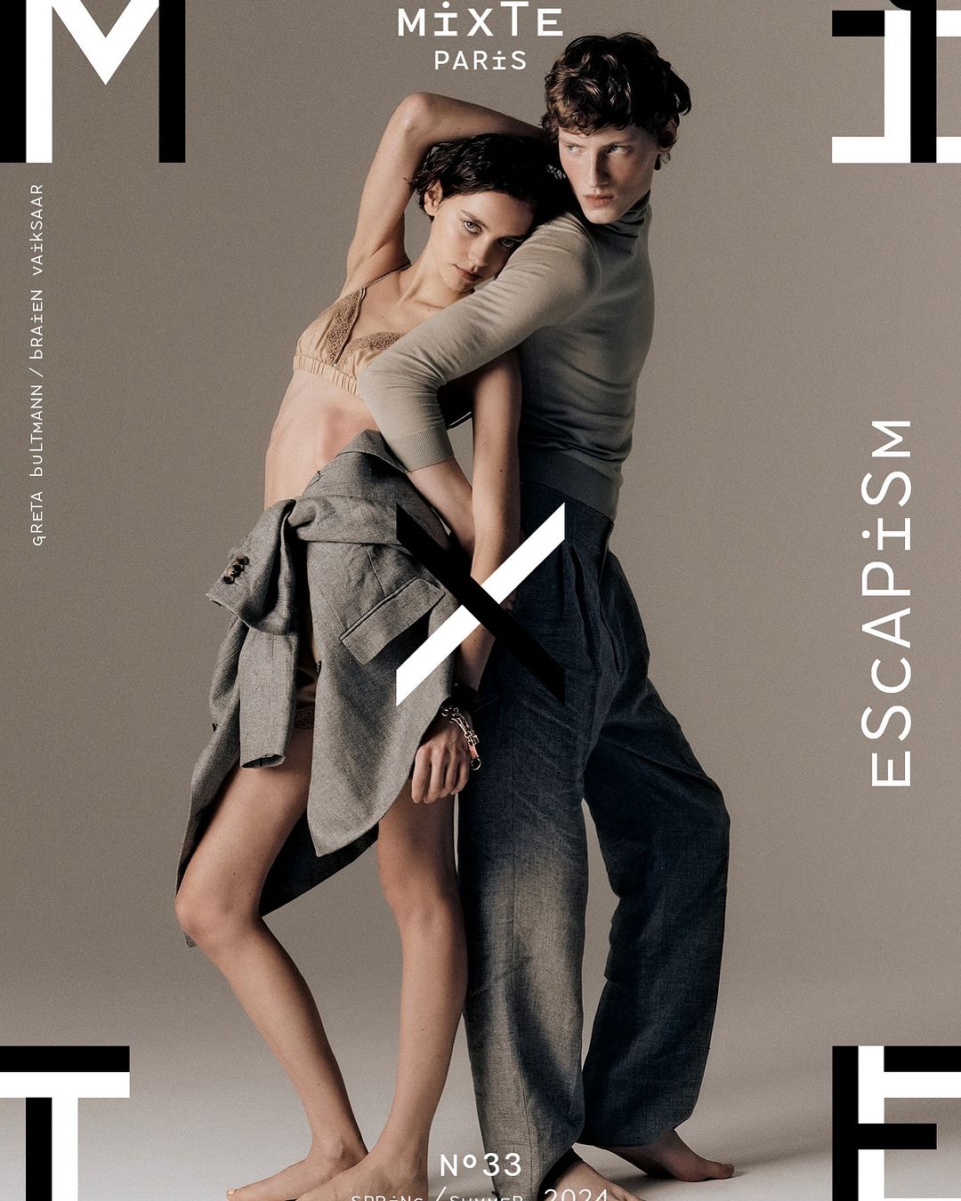 Fashion magazine cover featuring two androgynous models in stylish clothing, set against a neutral backdrop with bold typography and a minimalist aesthetic.