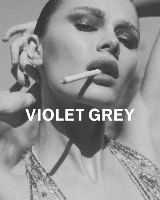 Striking black-and-white portrait of a model with a cigarette, showcasing dramatic makeup and a sequined top. Features bold 'VIOLET GREY' text.