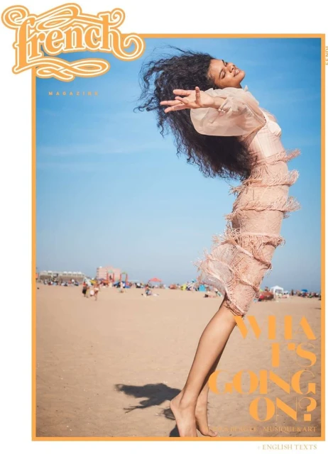 Magazine cover featuring a Black woman in a fringed dress on a beach with people enjoying a sunny day. The magazine title is French.