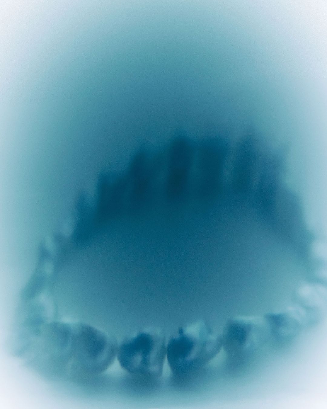 Dental impression shows teeth in a close-up shot, with soft focus highlighting the shape and contours in shades of blue and white.