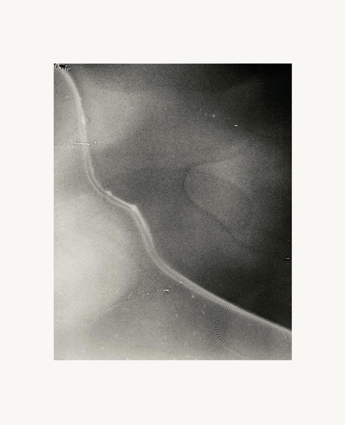 Monochromatic abstract image featuring a smooth, curved form with gradients of black and white, creating a serene and minimalistic composition.
