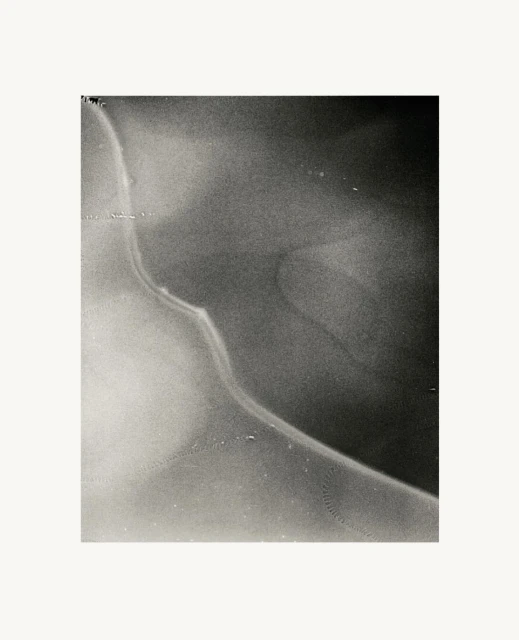 Monochromatic abstract image featuring a smooth, curved form with gradients of black and white, creating a serene and minimalistic composition.