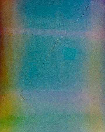Flock of birds in flight forming a diagonal line in a soft-focus, abstract gradient background in shades of blue, green and yellow.