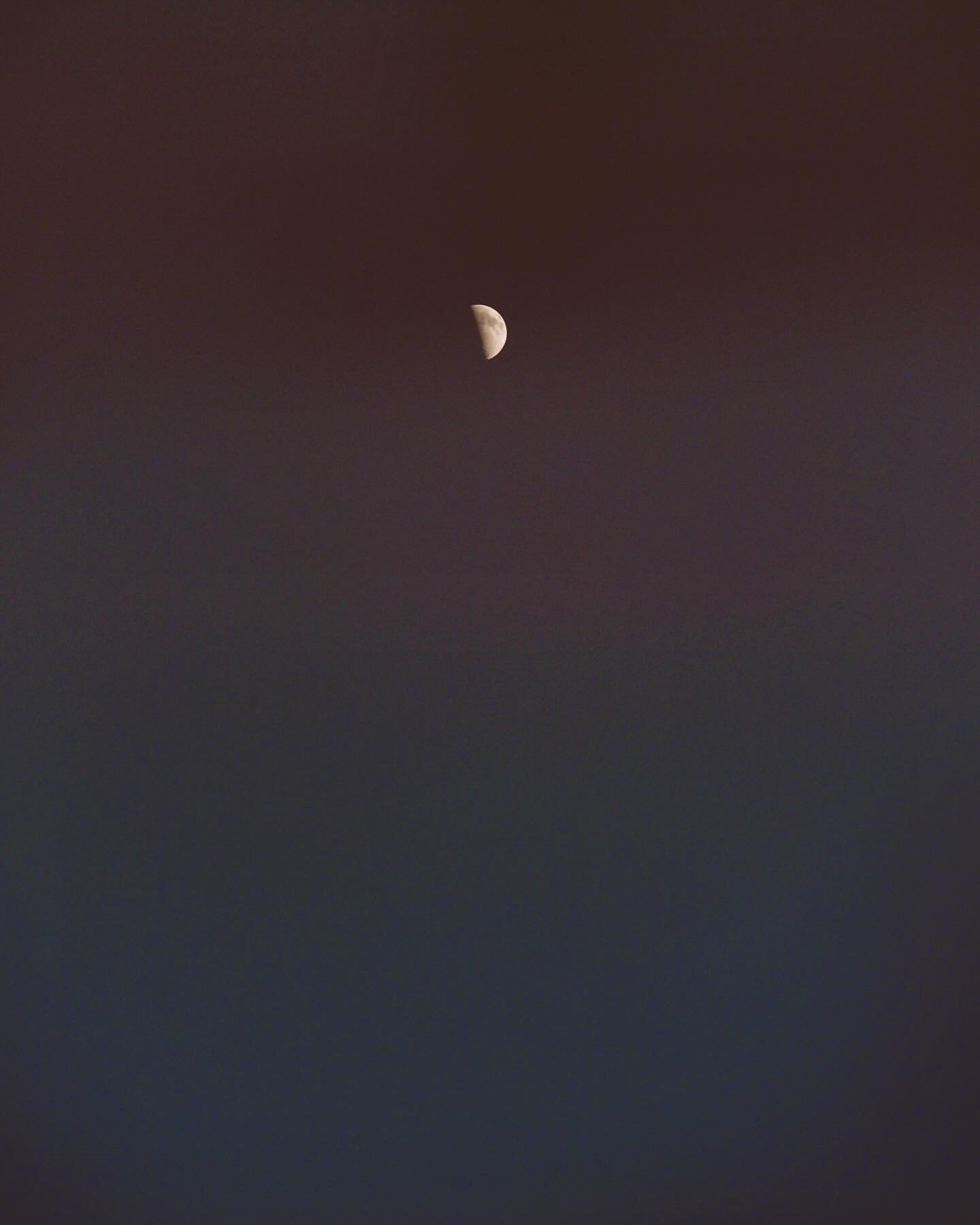 Crescent moon in the night sky against a dark gradient background. The lunar phase is the primary focal point.