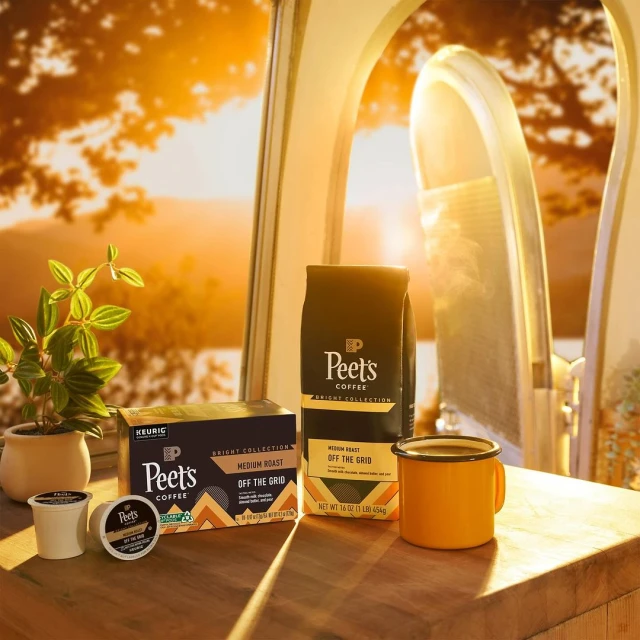 Peet's Coffee products including coffee bags and single-serve coffee pods are displayed next to a plant, bathed in warm sunlight.