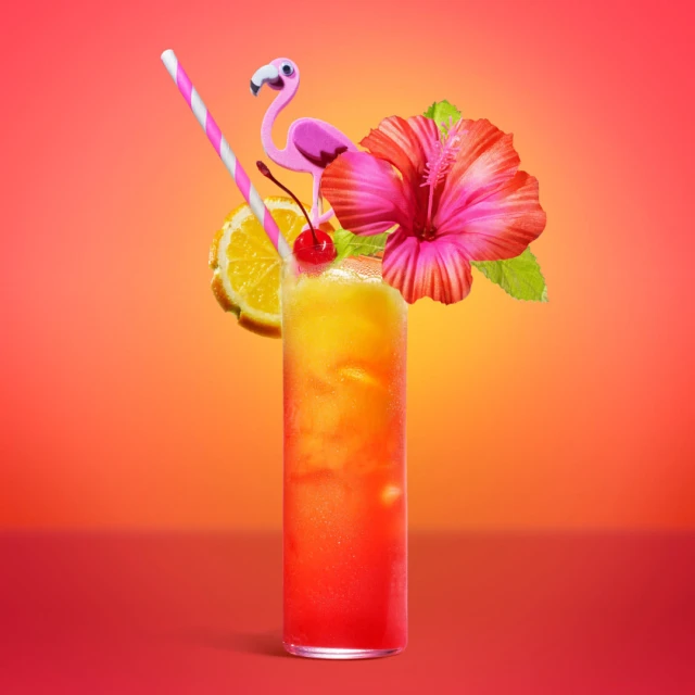 Vibrant tropical cocktail with a hibiscus flower, flamingo, orange slice, and cherry, set against a warm gradient background.