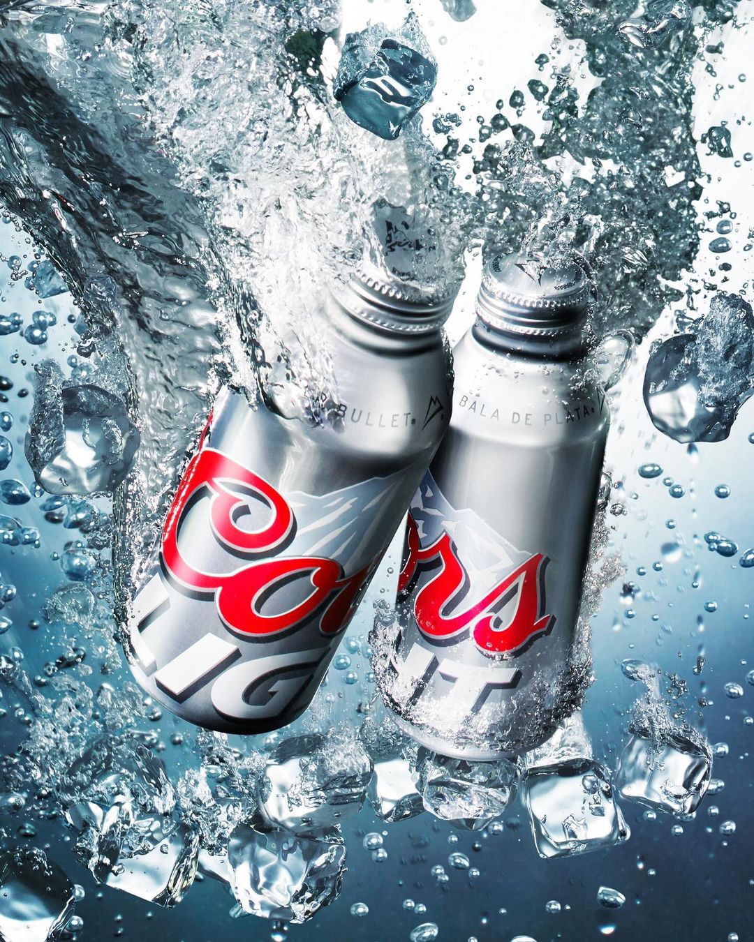 Two Coors Light aluminum beer bottles are partially submerged among ice cubes, water droplets, and splashes against a gradient background.