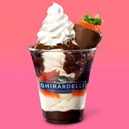 Chocolate sundae in a clear plastic cup with whipped cream and a chocolate-dipped strawberry by Annabelle Breakey