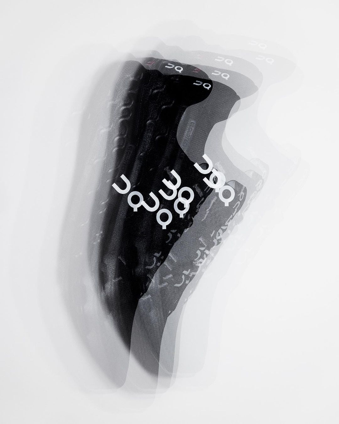 Multiple exposure studio shot of a running shoe with white graphics, captured against a clean white background.
