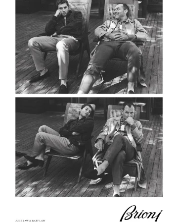 Black and white studio shot of Jude Law and Raff Law sitting in chairs, wearing casual clothes, and posing for a Brioni ad.