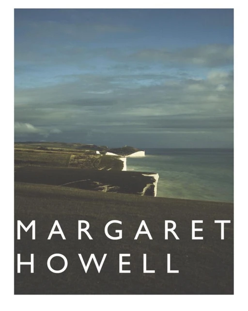Landscape shot features white cliffs along a sea with a cloudy sky; below is displayed the text 'MARGARET HOWELL' in block letters.